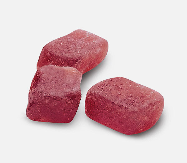 Zuckerreduktion Drei Stücke eines Fruchtgranulats aus der Nähe.