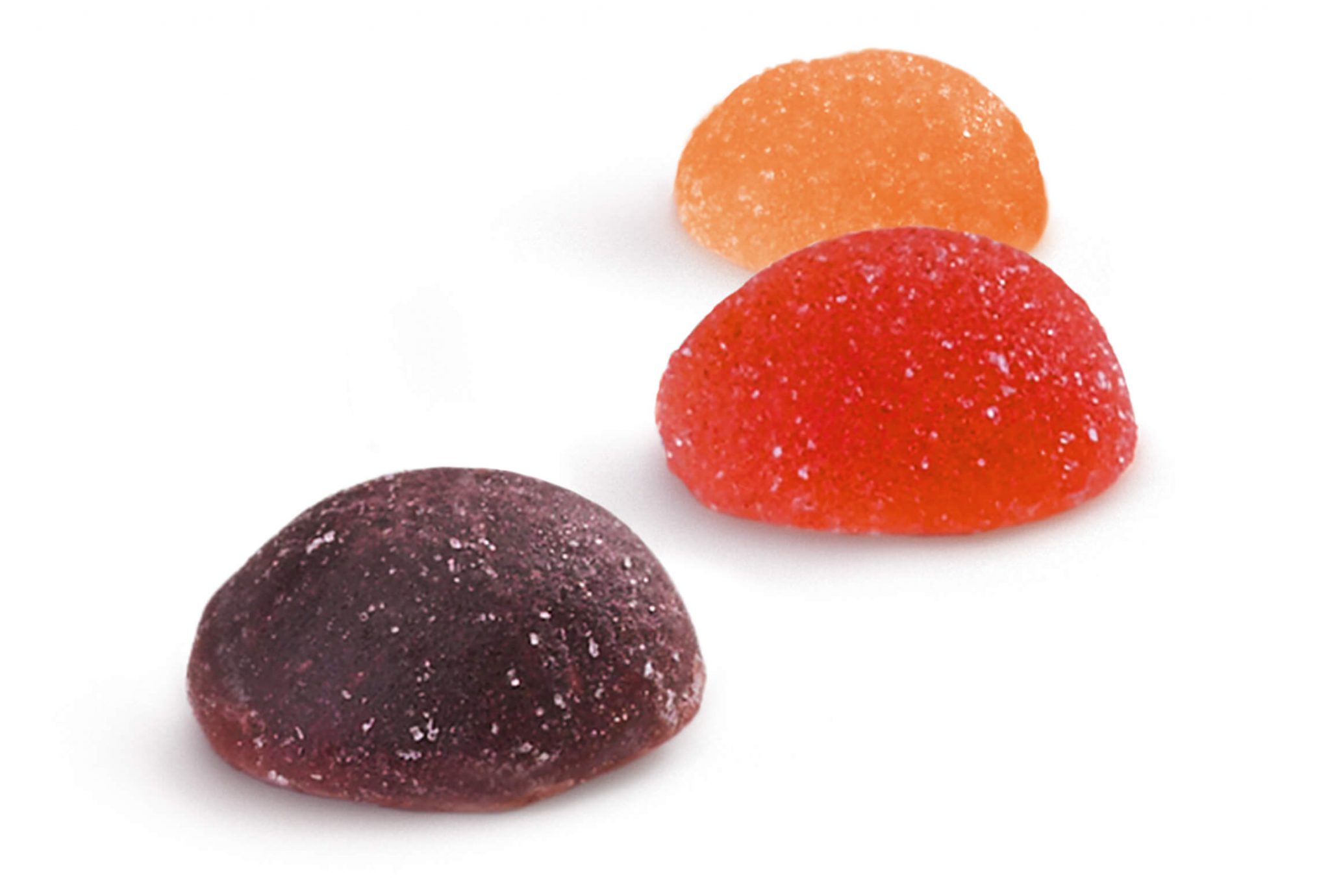 Healthy Snacks– Wellness für die Hosentasche Ein violetter, roter und orangefarbener Fruit Juice Drop, die nebeneinander angeordnet sind.