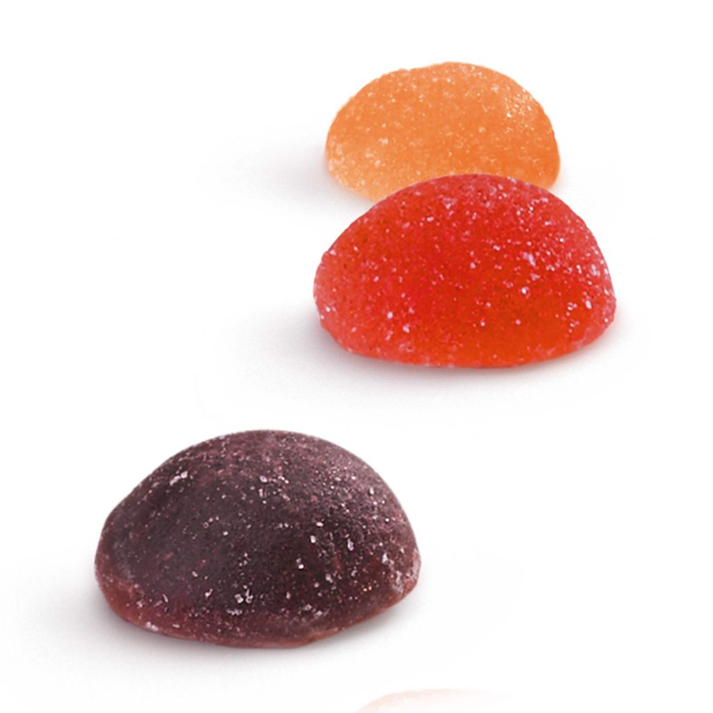 A purple, red and orange fruit juice drop positioned next to each other.