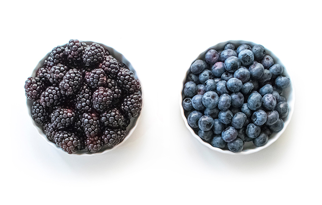 Paradise Fruits Blog Eine Schale mit frischen Brombeeren neben einer Schale mit frischen Heidelbeeren.