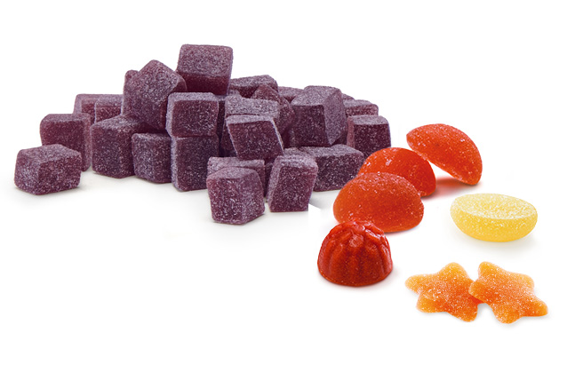 Paradise Fruits Blog Lecker Fruchtgranulate, Fruit Shapes und Fruit Juice Drops in verschiedenen Orange- und Lila-Tönen.